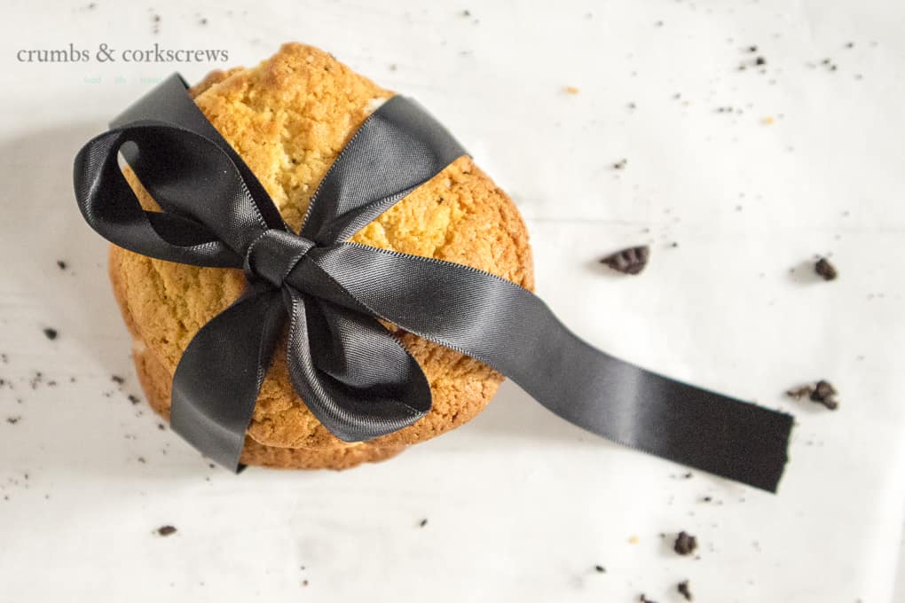 Stack of cake mix cookies tied with a black ribbon and cookie crumbs scattered around
