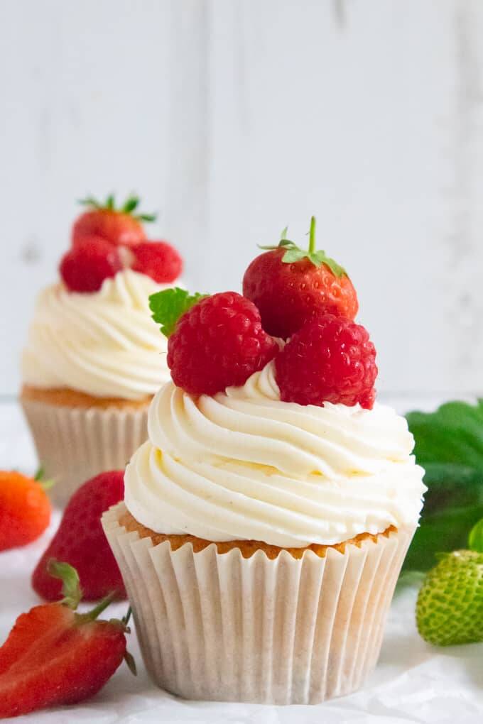 A Cotswolds summer all wrapped up into an afternoon inspired Strawberries and Cream cupcakes – a fluffy sultana sponge, filled with strawberry jam, topped with a clotted cream buttercream and fresh summer fruit