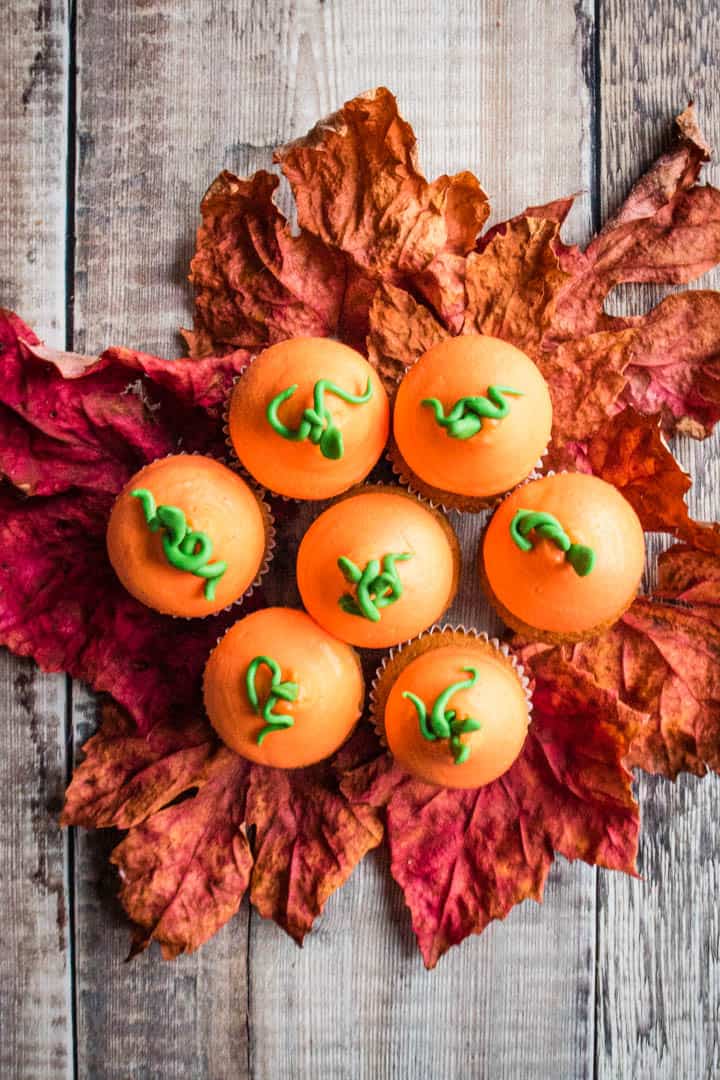 A group of pumpkin spice cupcakes on maple leaves
