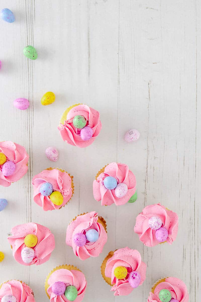 Delight your friends and family for Easter with these cute and delicious mini egg cupcakes. Soft white chocolate cake speckled with coloured candy drops, and topped with a fluffy white chocolate buttercream frosting and the best Easter candy ever... mini eggs.
