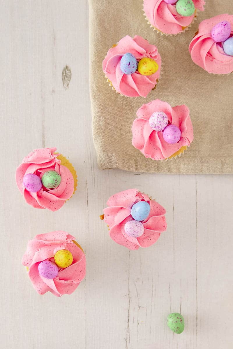 Delight your friends and family for Easter with these cute and delicious mini egg cupcakes. Soft white chocolate cake speckled with coloured candy drops, and topped with a fluffy white chocolate buttercream frosting and the best Easter candy ever... mini eggs.