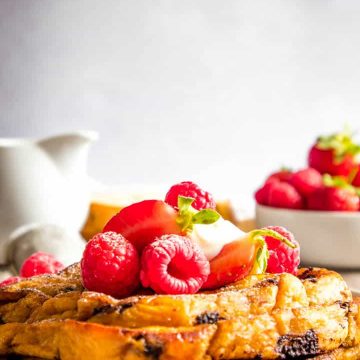 Stack of chocolate chip brioche french toast with berries on top