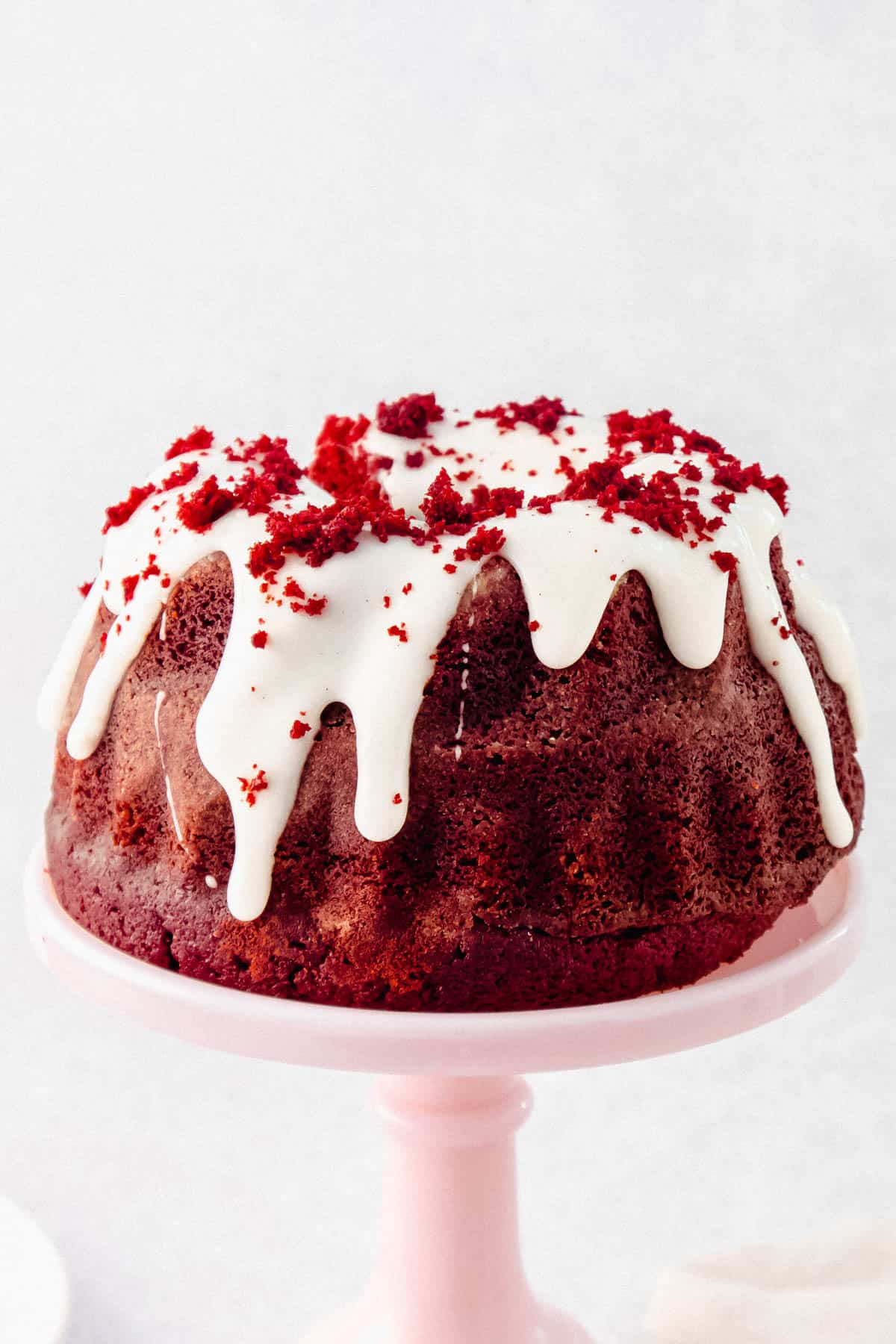 Red Velvet bundt cake covered in cream cheese glaze and sprinkled with cake crumbs