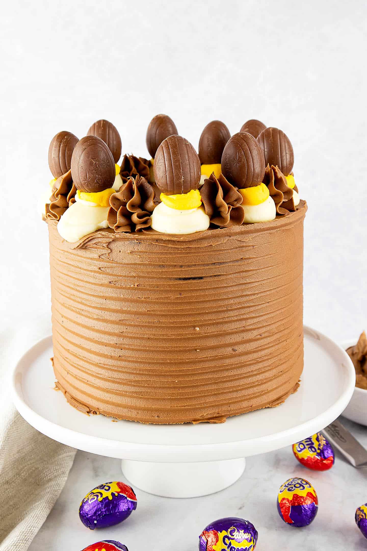 Chocolate Creme Egg cake on a white cake stand