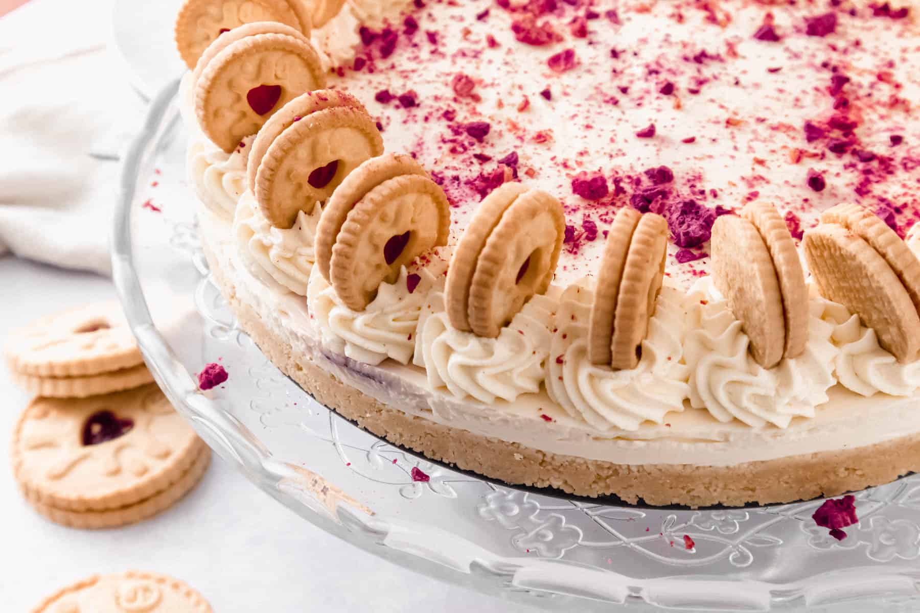 Cheesecake decorated with mini biscuits and raspberry powder