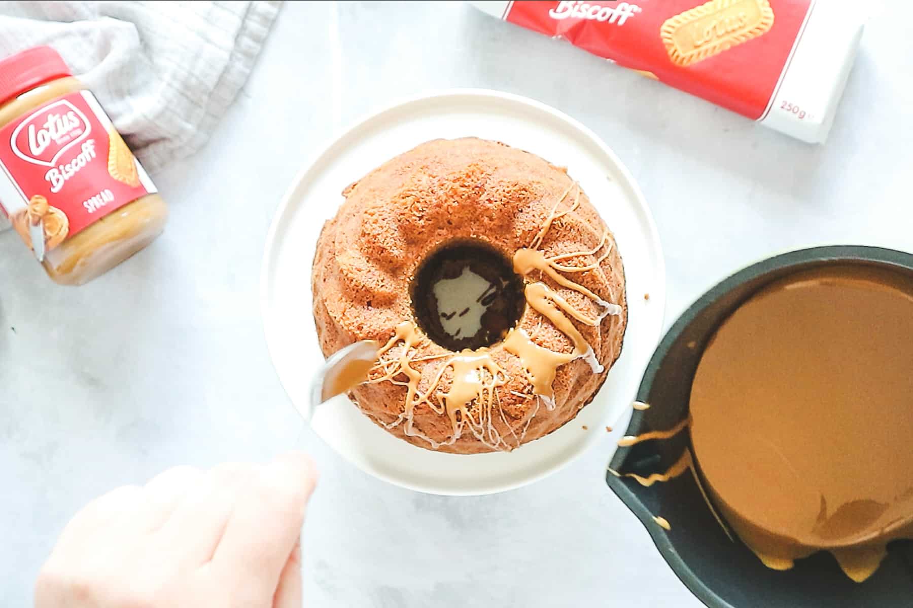 Drizzling melted Biscoff glaze over the top of the Bundt cake
