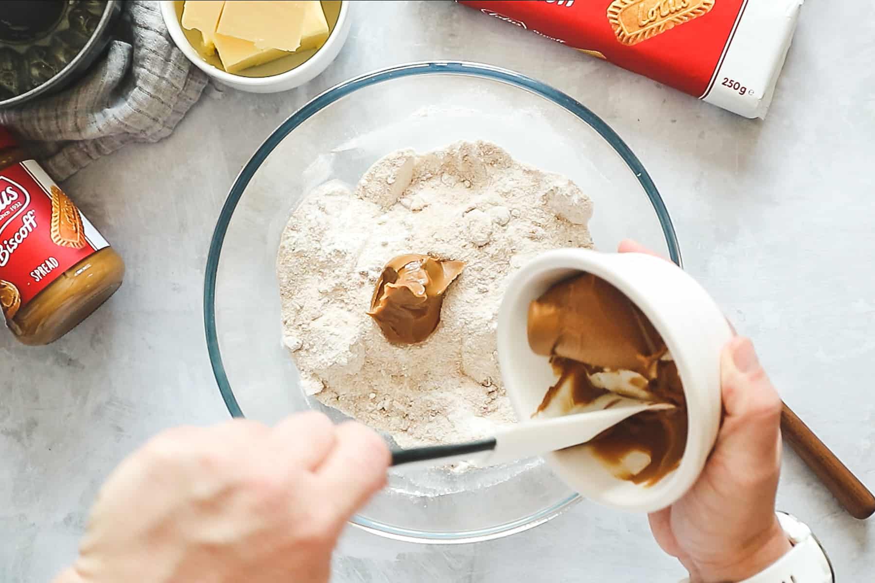 Adding Biscoff spread to dry ingredients in a large mixing bowl