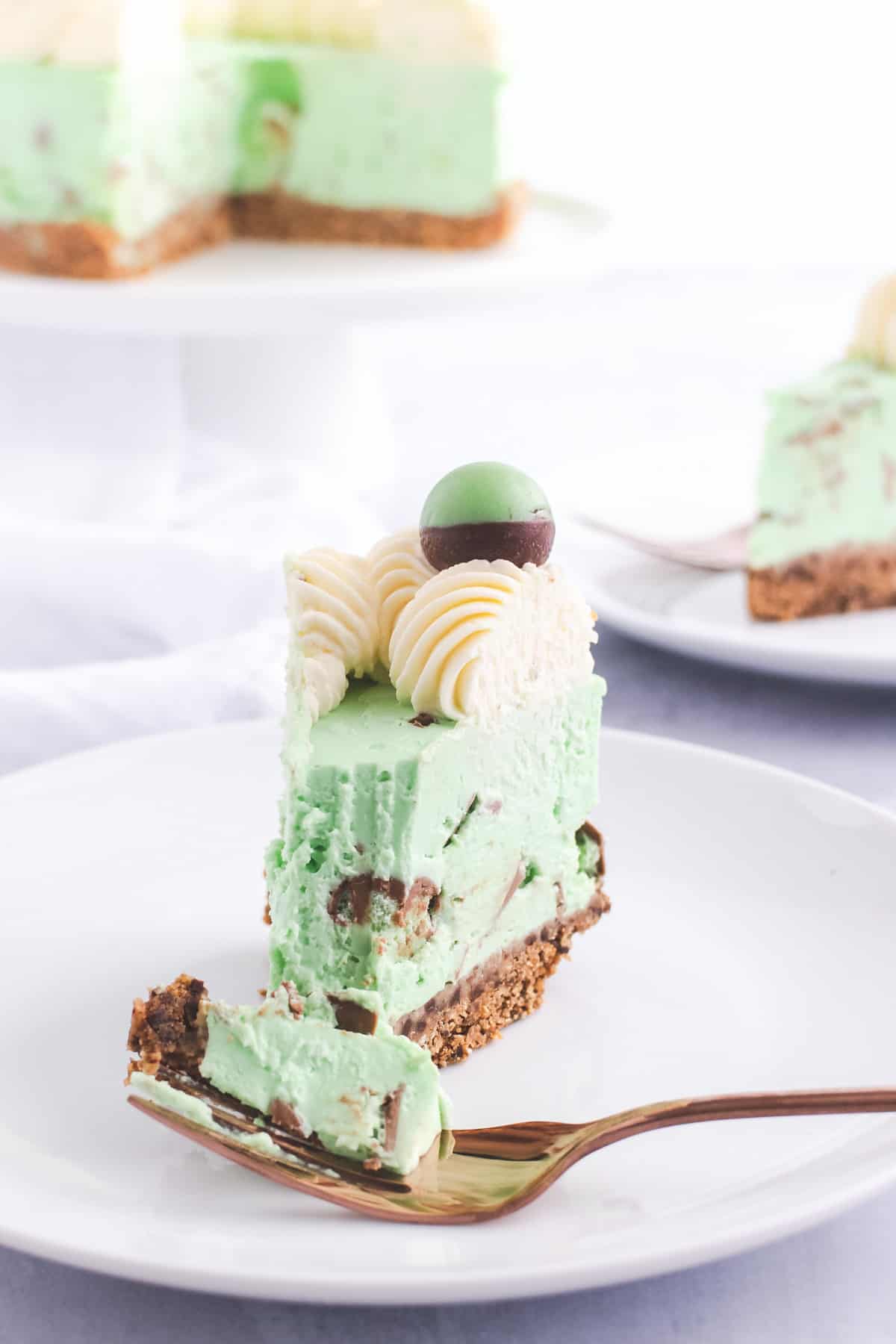 Green cheesecake on a fork, on a white plate
