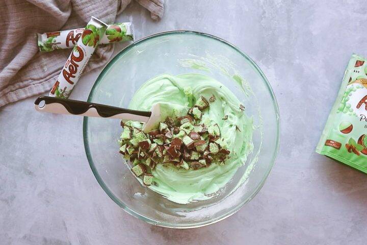 Adding chocolate chunks into a green cheesecake filling