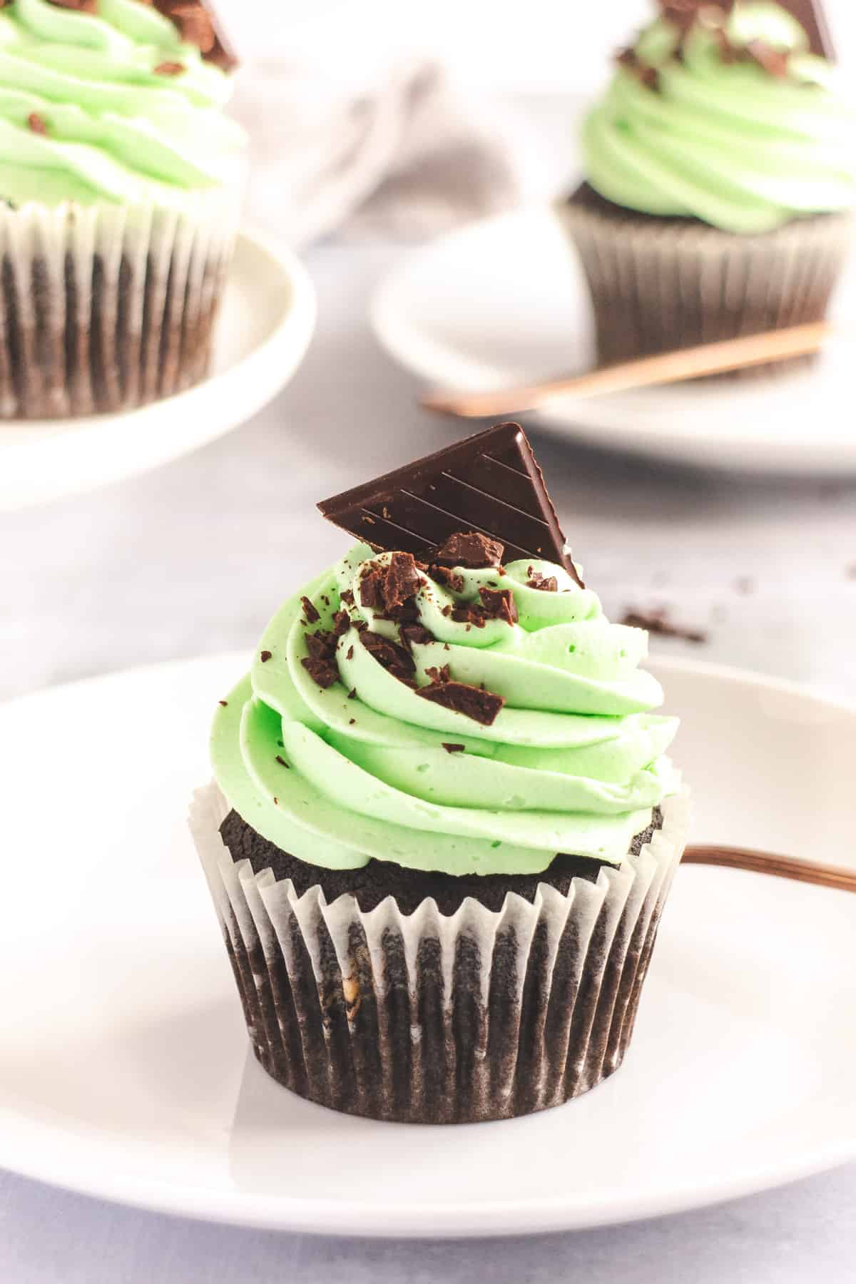 Chocolate cupcake with mint green frosting on a white plate