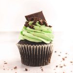 Mint chocolate cupcake surrounded by chocolate pieces