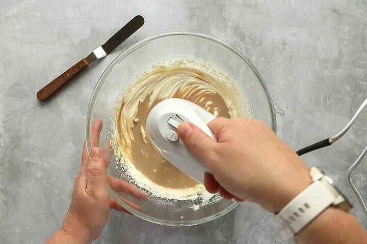 Whisking cream in a bowl with a handheld miser
