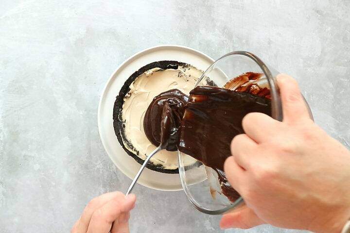 Pour melted chocolate over a Baileys cheesecake