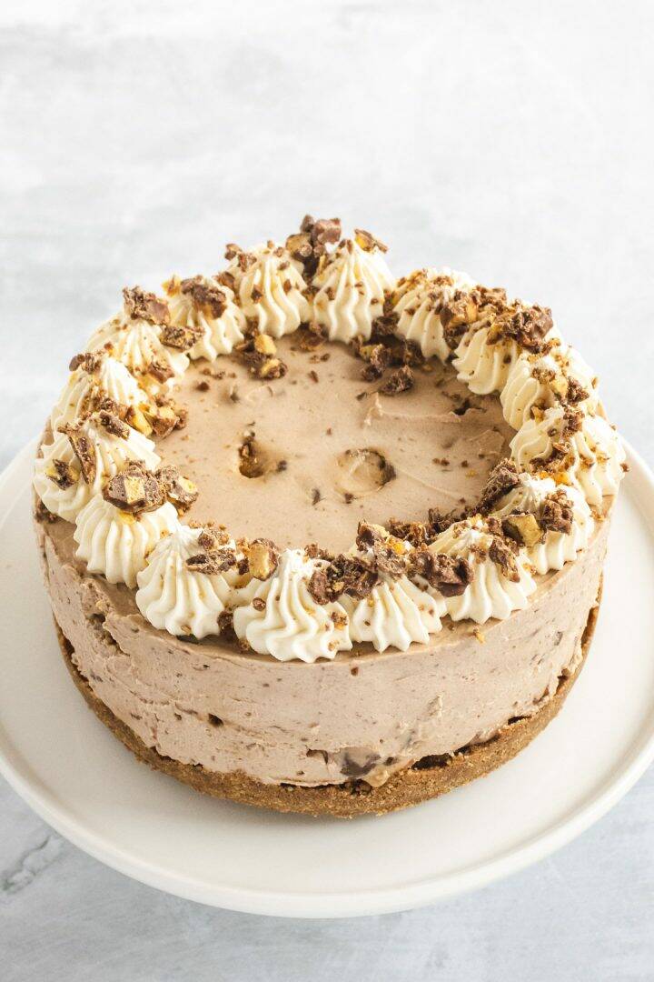 Chocolate honeycomb dessert decorated with cream swirls and chocolate pieces