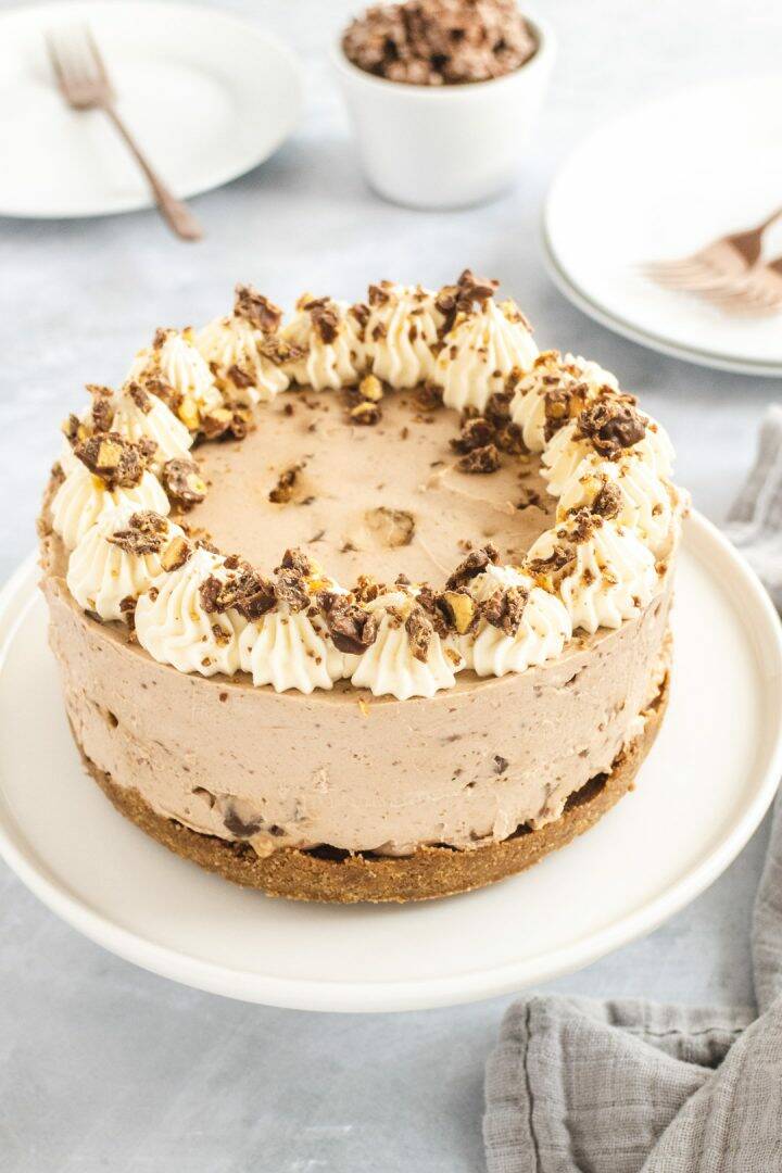 Chocolate honeycomb cheesecake decorated with cream swirls and chocolate bar pieces