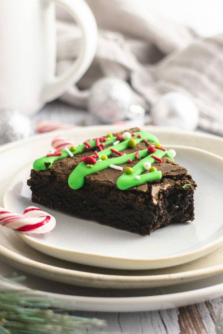 Brownie decorated with green icing and sprinkles, with a bite taken out of it