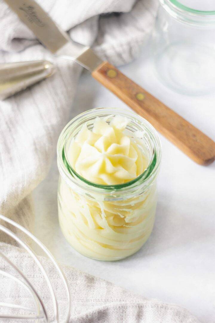 Swirl of pale cream buttercream in a glass jar