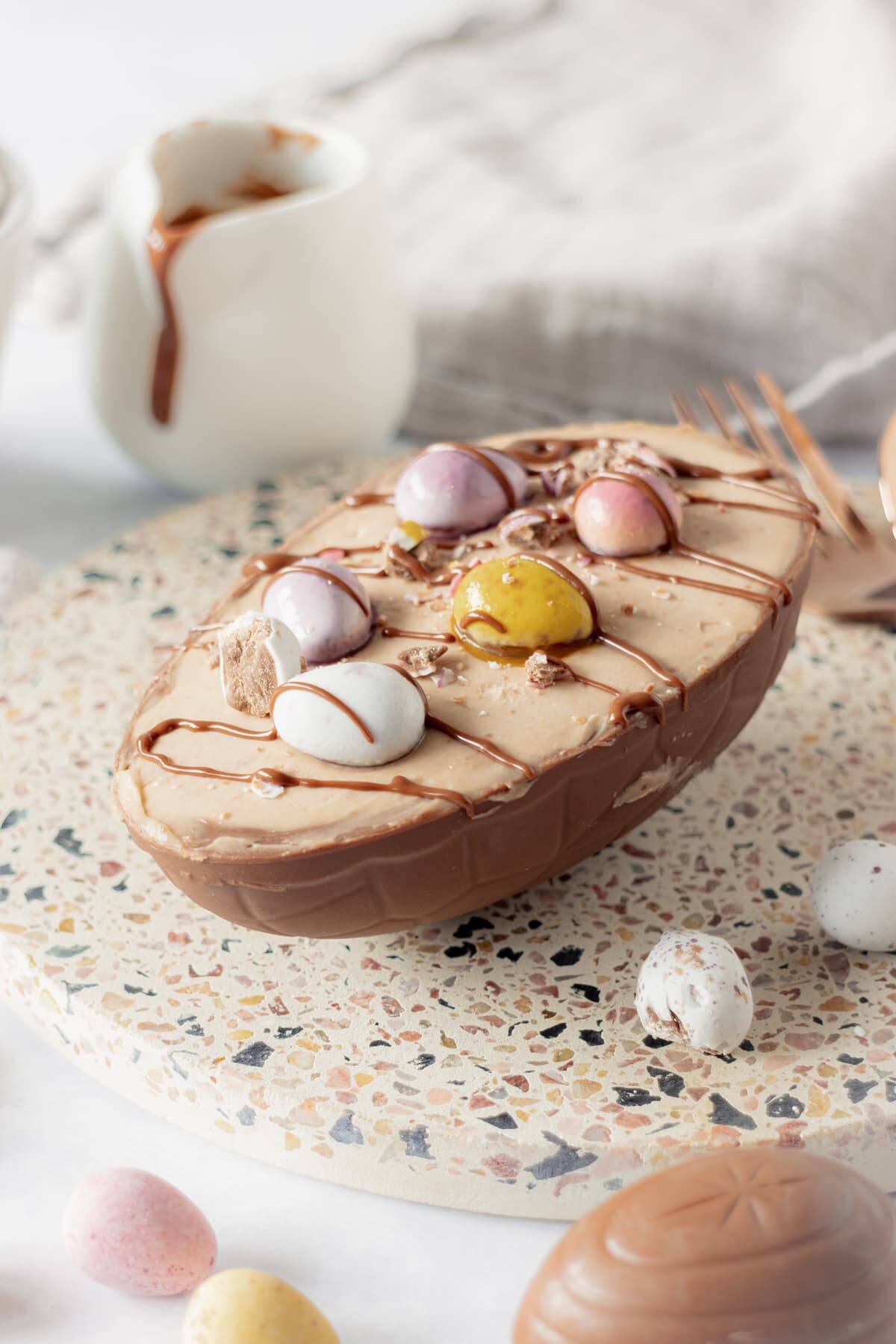 Easter egg filled with chocolate filling, topped with Mini Eggs and drizzled with chocolate sauce