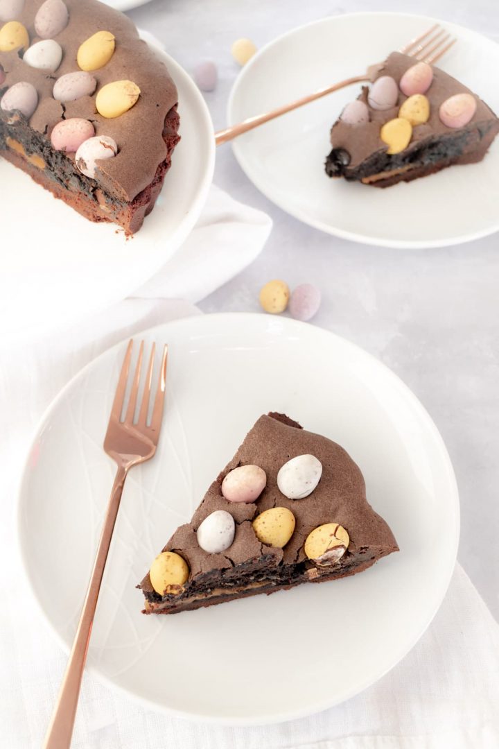 Slice of Easter chocolate tart on a white plate with fork