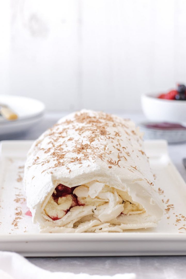 Meringue roll filled with cream and sprinkled with chocolate