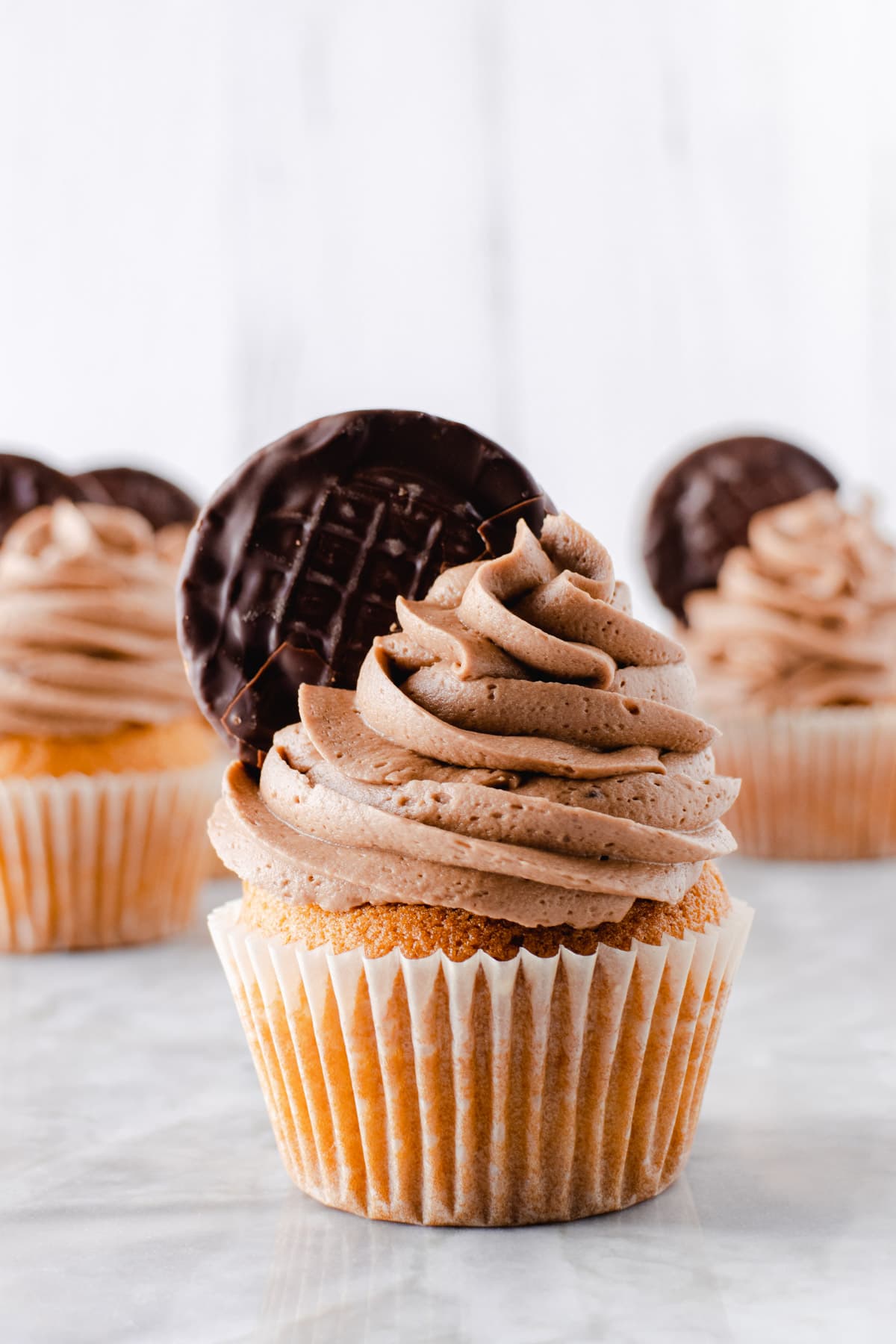 Cupcakes topped with orange chocolate frosting and Jaffa Cakes