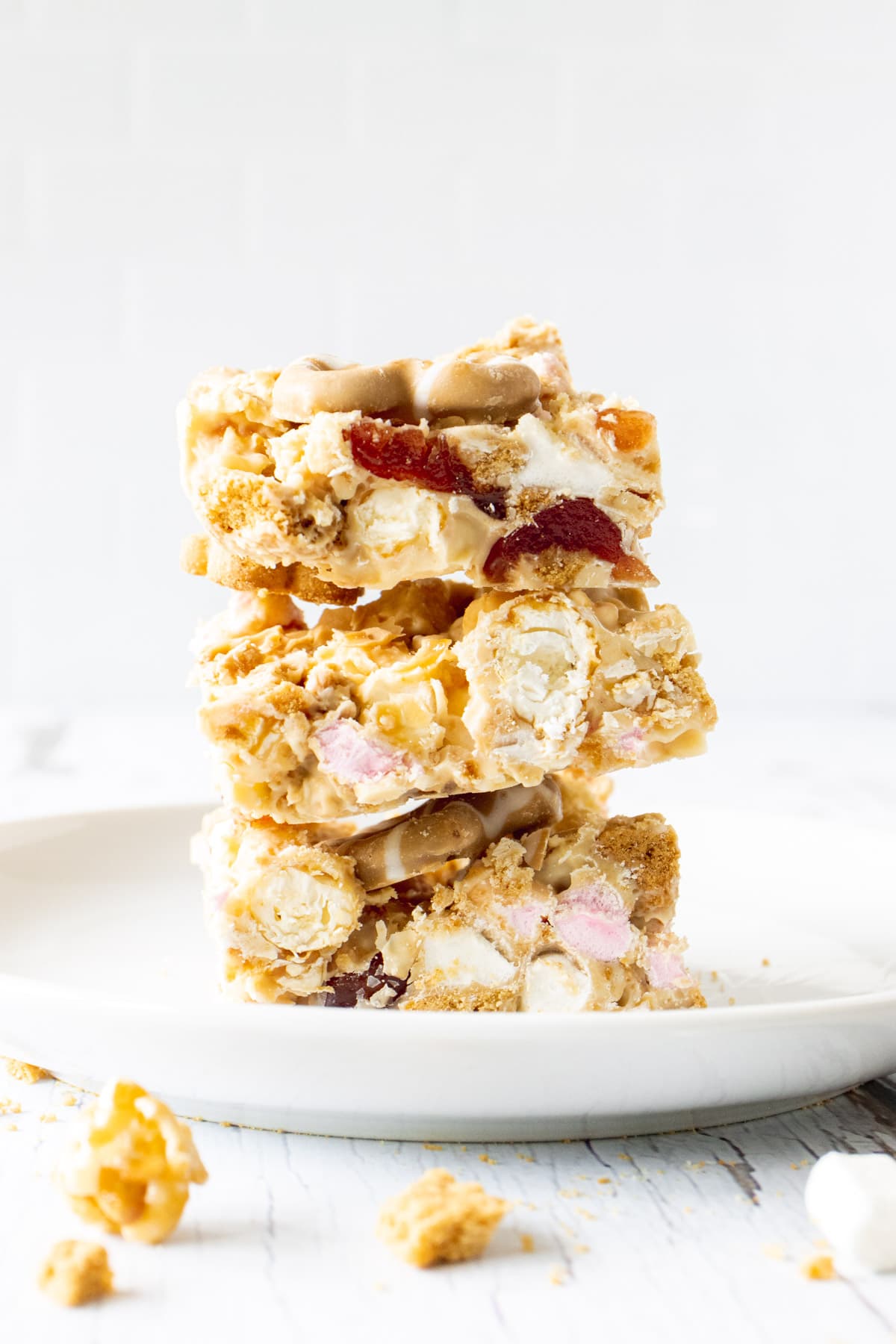 Stack of fridge cake slices filled with marshmallows, popcorn and cherries