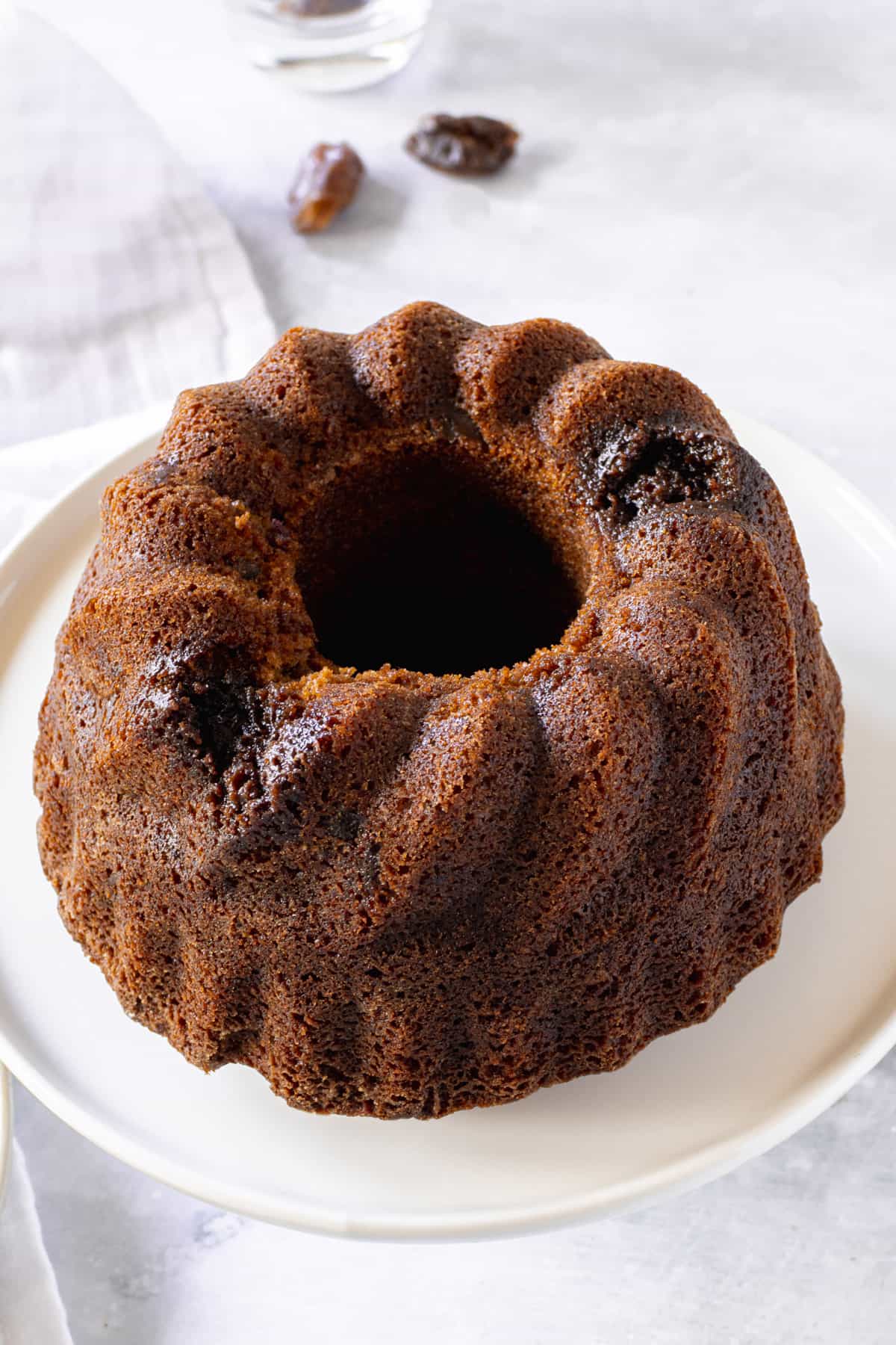 Date infused bundt cake on a white cake plate