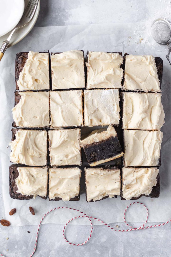 Slab of mince pie brownie cut into squares, one square is sat on the end to show the different layers