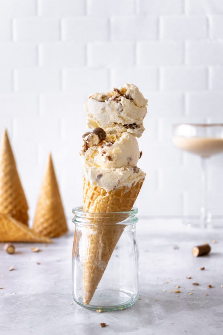 Scoops of Baileys Ice cream on top of a waffle cone stood up in a glass jar