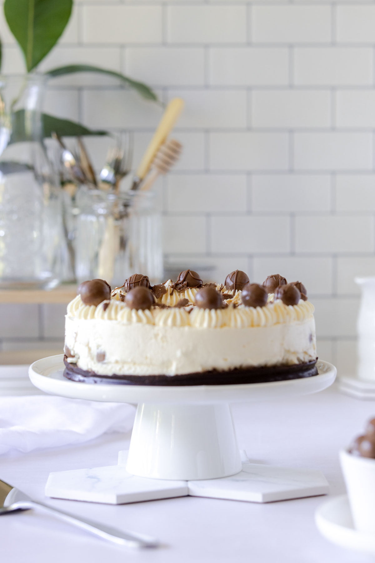 Maltesers cheesecake on a white cake plate