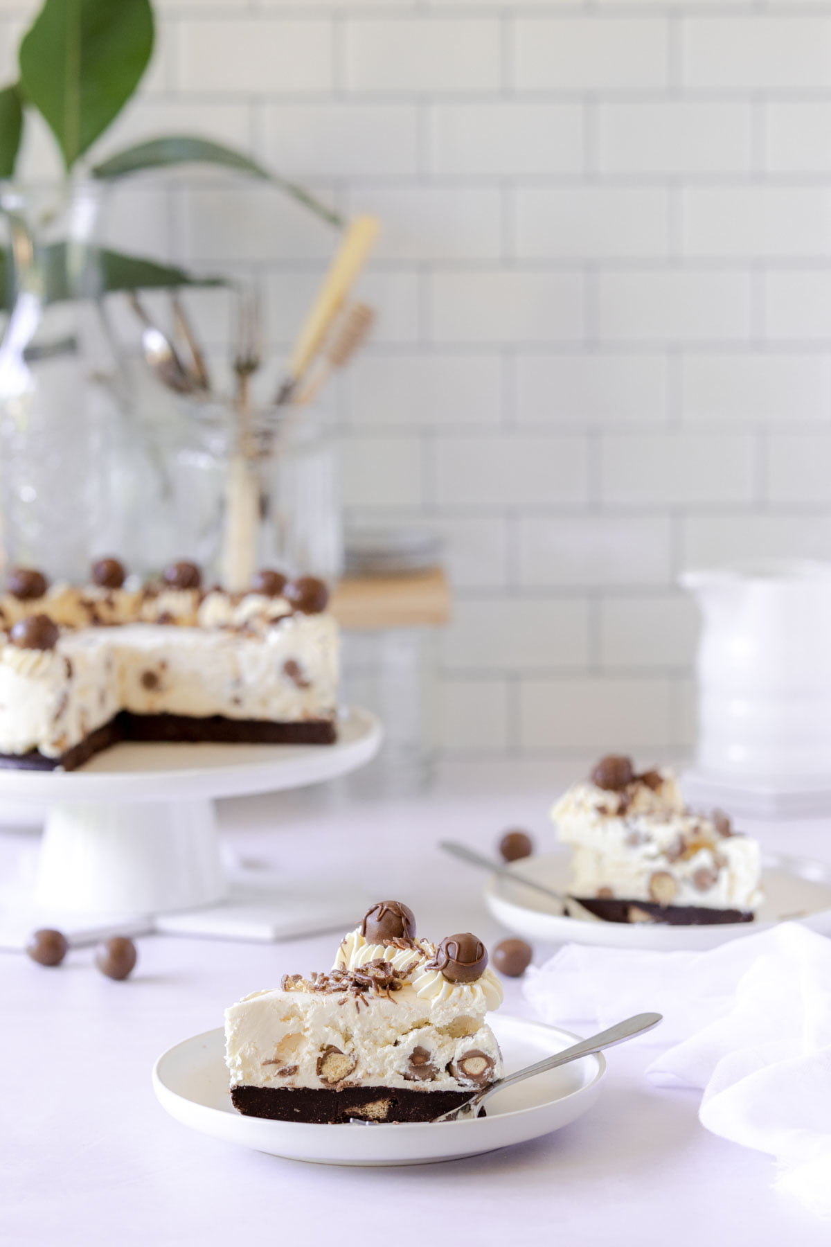 Slice of Malteser cheesecake, with a chocolate biscuit base and cheesecake filling packed with Maltesers