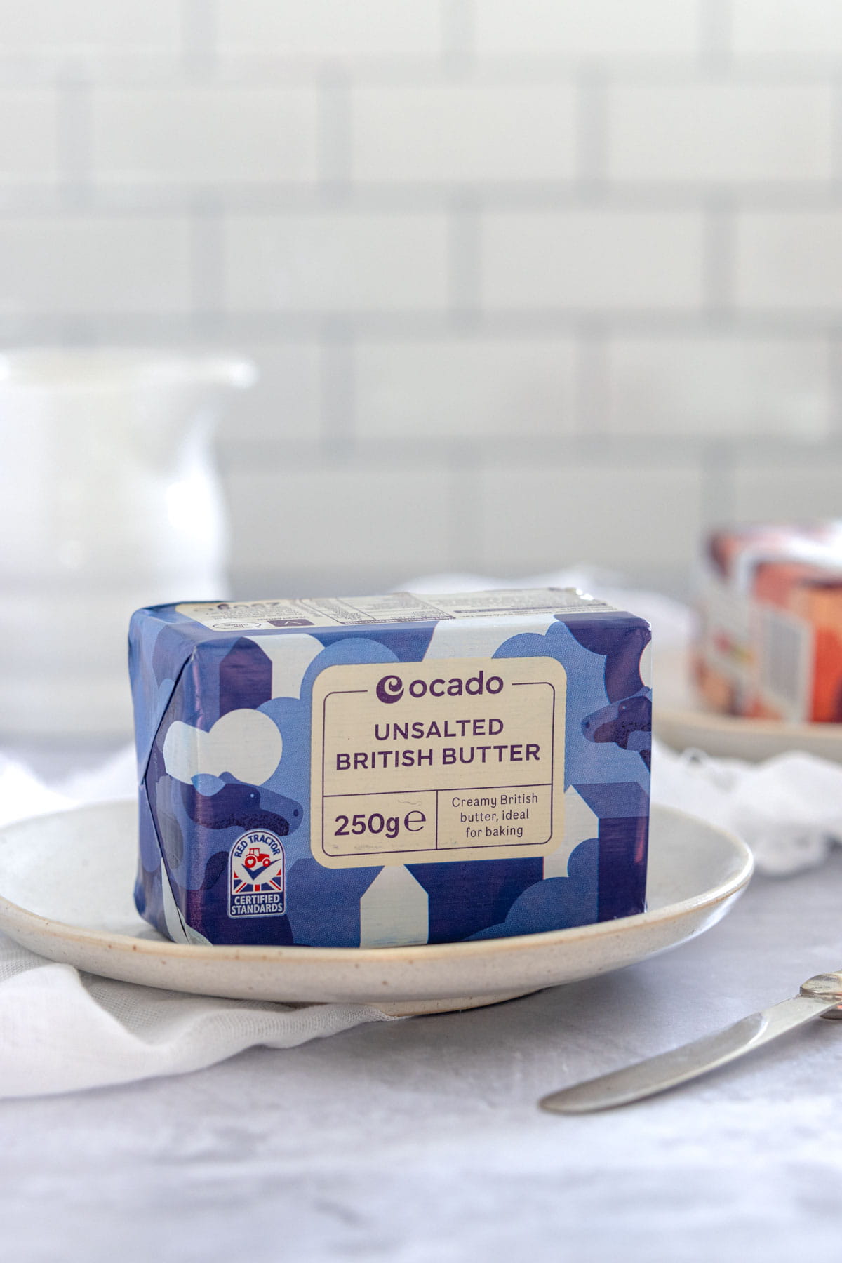 A pack of butter in a blue wrapper with writing on saying unsalted British butter