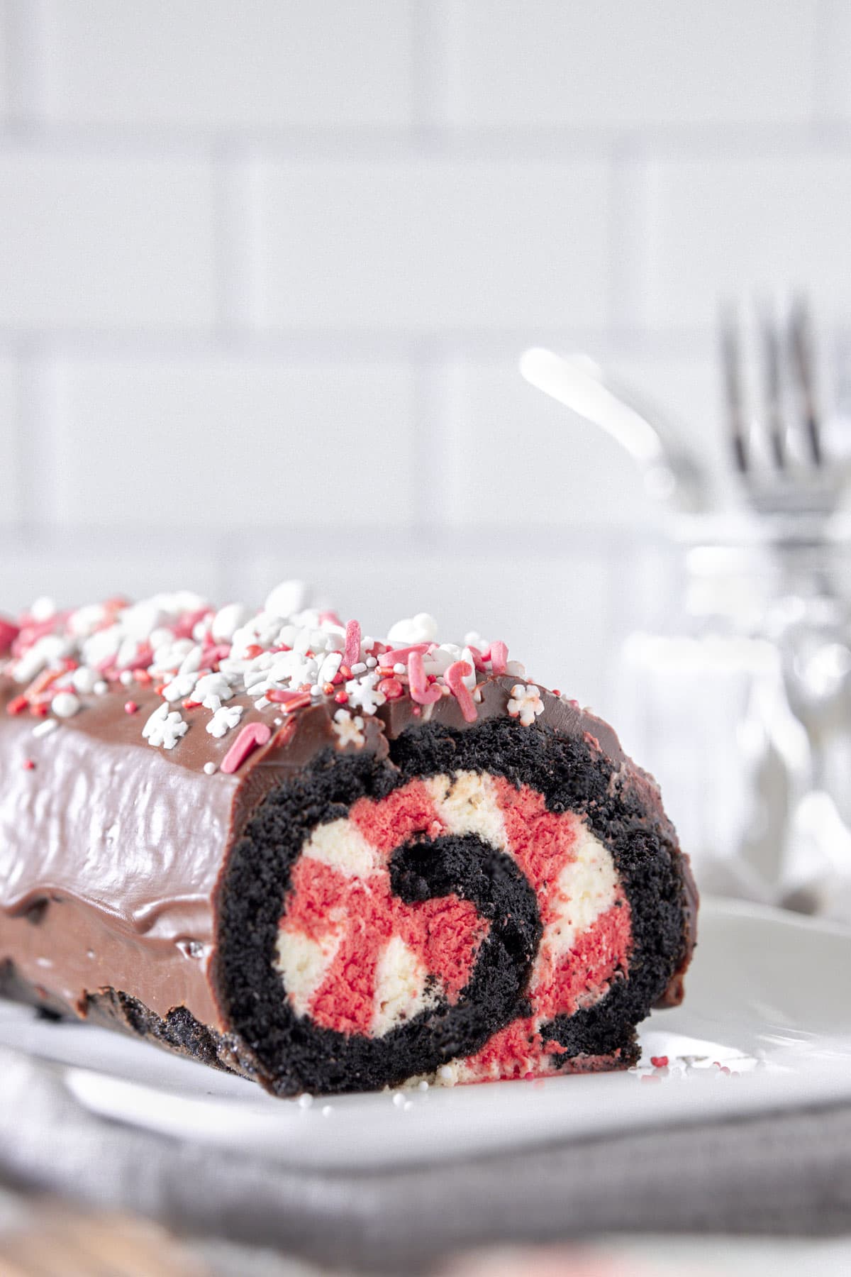 Chocolate Peppermint Swiss Roll filled with red and white cream, on a white plate