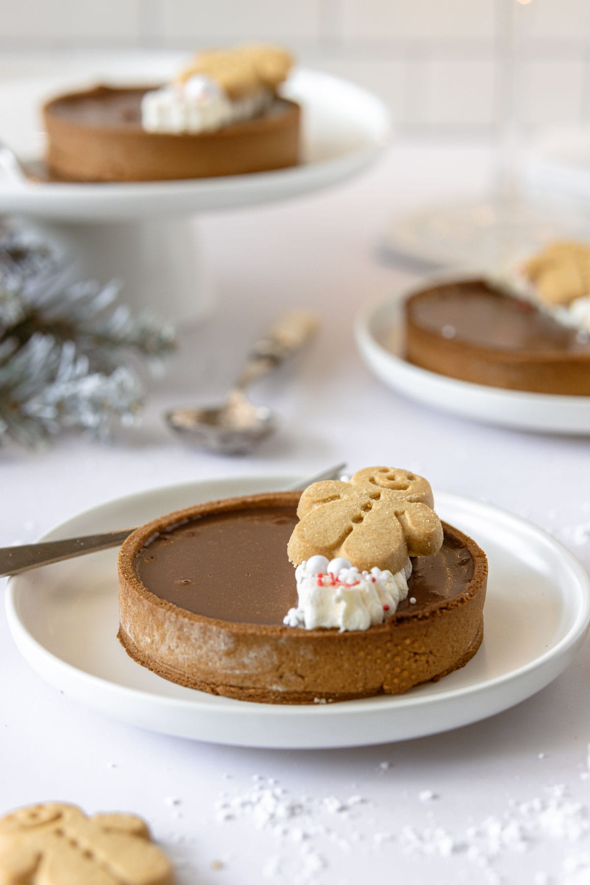 Gingerbread chocolate tart on a white plate with a fork