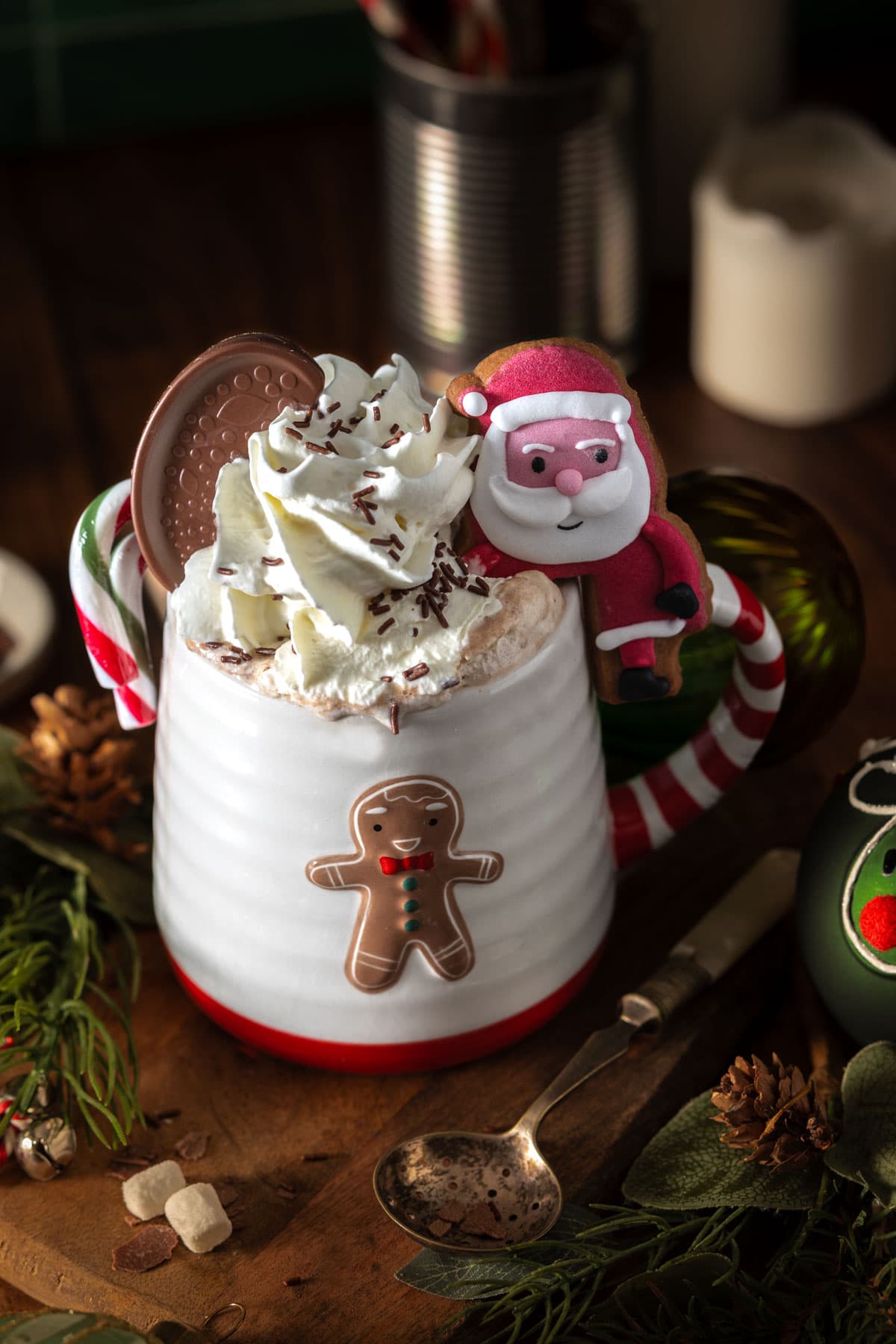 Mint hot chocolate in a red and white mug with a candy cane and whipped cream on top
