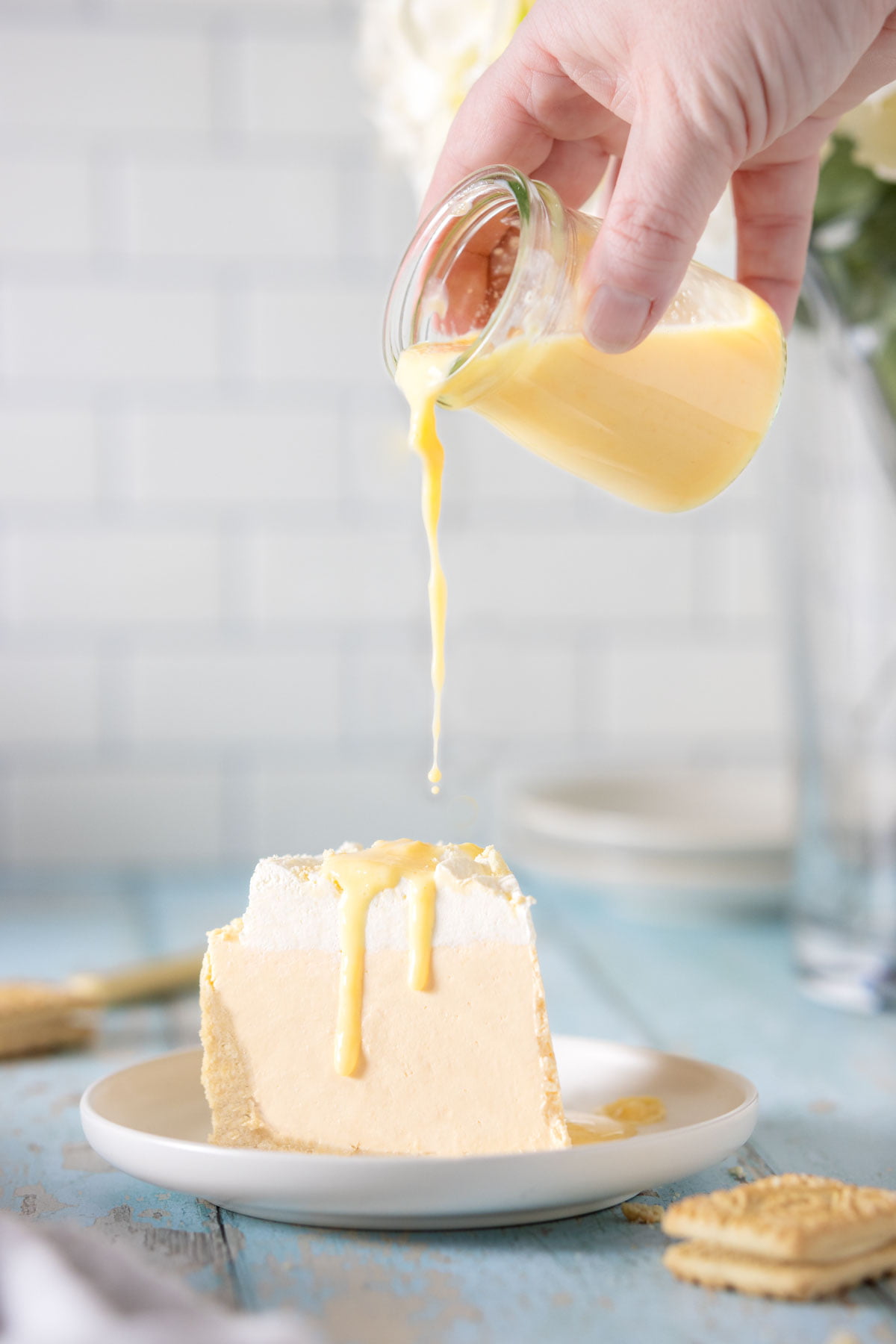 Custard being poured over a slice of no bake cheesecake