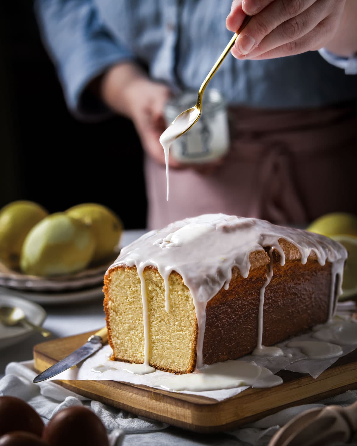 Drizzling icing over the top of a lemon loaf cake - Food Photography and Styling by Lou Carruthers, Crumbs and Corkscrews