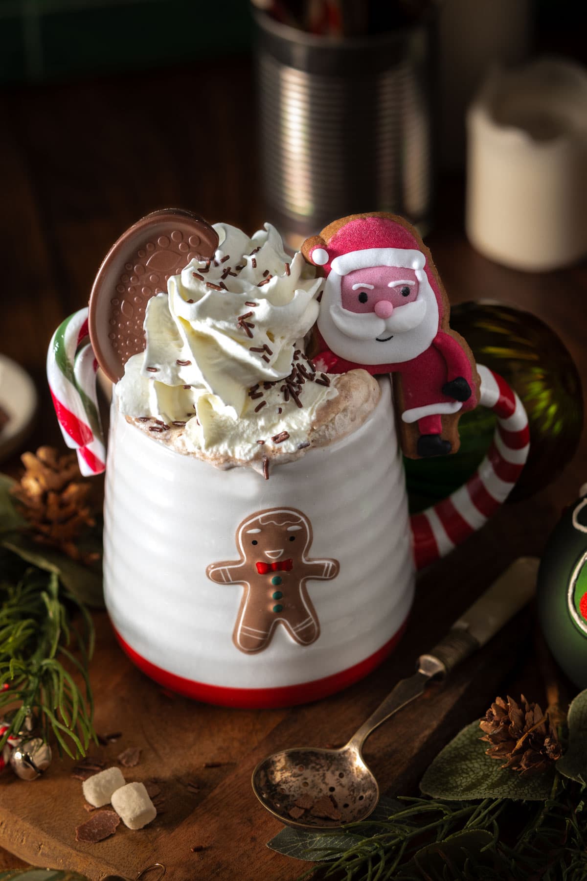 Hot chocolate topped with whipped cream in a Christmas mug with a gingerbread man on the front - Food Photography and Styling by Lou Carruthers, Crumbs and Corkscrews